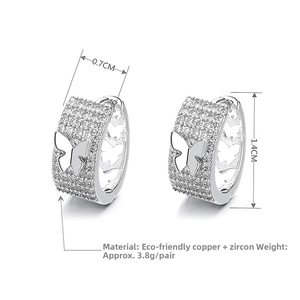 Macro detail of silver butterfly hoop earrings with cubic zirconia and hollow patterns