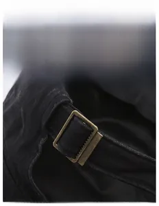 Close-up of vintage black cotton military cap with adjustable bronze metal buckle strap