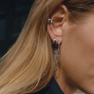 Primo piano di orecchini a catena con nappine e ear cuff argentati in stile moderno minimalista