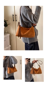 Detail view of large brown suede shoulder bag with long fringes and leather strap