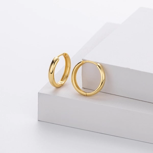 Close-up of golden S925 sterling silver hoop earrings with clear hallmark engraving
