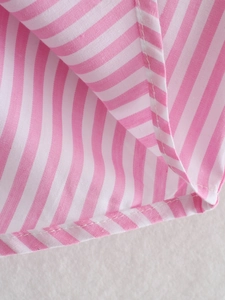 Detailed close-up of pink and white striped fabric texture and neat hem stitching
