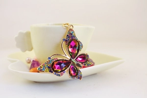 Detailed macro view of a gold butterfly keychain adorned with colorful crystals and rhinestones