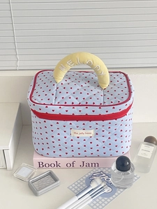 Light blue quilted makeup bag with red hearts and yellow handle labeled Melody