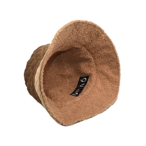 Detail view of brown quilted bucket hat with warm fleece lining and diamond pattern texture