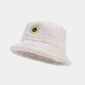 Detail of plush off-white faux fur bucket hat with embroidered sunflower patch decoration