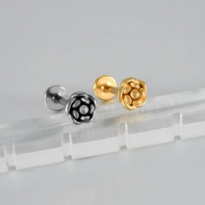 Macro de piercings de lèvre en forme de fleur dorée et argentée au fini métallique poli