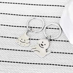 Close-up of funny stainless steel keychain set with dog and poop charms in silver