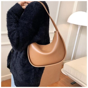 Sacoche demi-lune en cuir marron portée par un mannequin dans un cadre intérieur