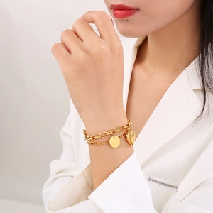 Detail of a 18K gold plated double layer heart bracelet worn on a woman's wrist
