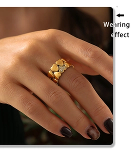 Close-up of vintage 18K gold plated heart ring with diamond accents worn by a model