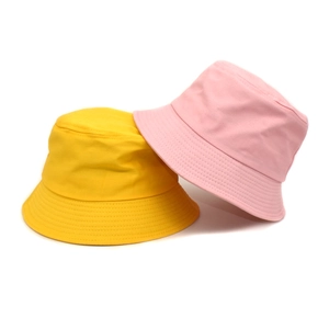 Minimalist solid cotton bucket hats in yellow and pink for sun protection outdoor leisure