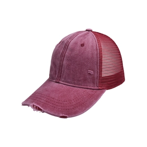 Detalle de la textura de algodón lavado y malla transpirable en una gorra de color burdeos