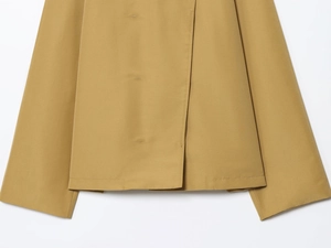 Close-up of khakhi windbreaker placket and hem stitching on smooth woven fabric