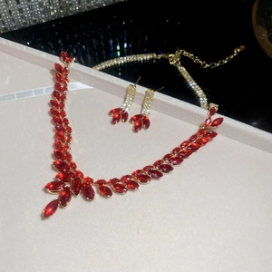 Close-up of elegant V-shaped necklace and matching earrings with red marquise stones