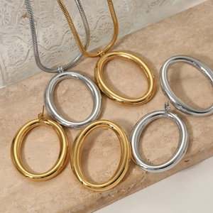 Elegant gold and silver geometric oval jewelry set on beige stone over embossed glass