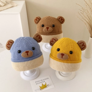 Three children's thick knitted bear hats in blue brown and yellow with cute ear details