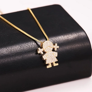 Macro detail of gold-plated girl pendant with pavé cubic zirconia on box chain necklace