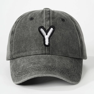 Macro detail of the white embroidered letter Y on vintage washed grey cotton baseball cap