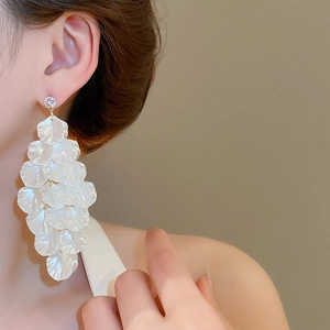 Detail of white layered resin petal earrings with sparkling rhinestone on a model