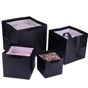 Set of four black square kraft paper gift bags with handles in various sizes