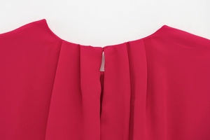 Detailed close-up of pleated crew neck and chiffon texture on magenta sleeveless romper