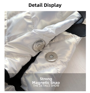 Detail view of the strong magnetic buckle on a silver quilted tote bag with metallic finish