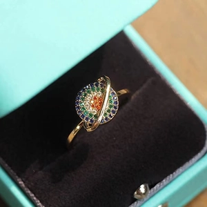 Macro shot of gold planet ring with colored gems inside a light blue jewelry gift box