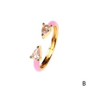 Detail of a 18K gold plated open ring with pink enamel and pear-cut zircon stones