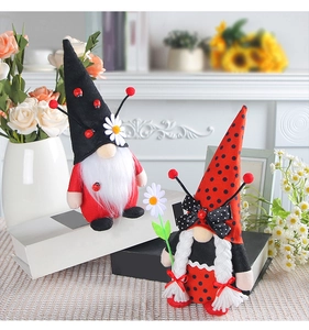 Detail view of ladybug gnome plush dolls set on books for cozy home decoration