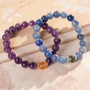 Elegant purple amethyst and citrine beaded stretch bracelets on a vintage book surface