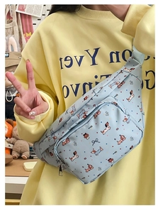 Detail of light blue crossbody chest bag with cute cartoon dog prints and silver zipper