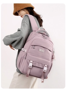 Detail view of purple waterproof nylon backpack with side straps and brand logo tag