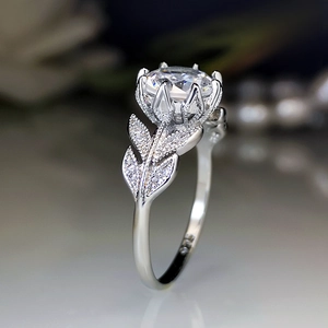 Elegant floral crown ring with leaf designs and a round-cut zircon in silver setting