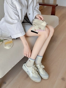 Close-up of cute sausage dog embroidery on cream knit cotton socks for women