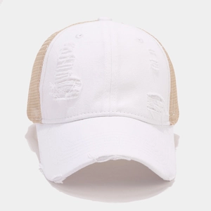 Detailed close-up of distressed white trucker hat with vintage torn fabric and mesh back