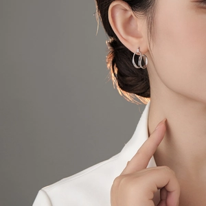 Detailaufnahme eines Models mit minimalistischen silbernen dreireihigen Creolen im Design