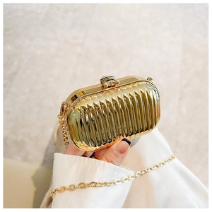 Detail of gold metallic pleated evening clutch bag with chain strap and sphere clasp