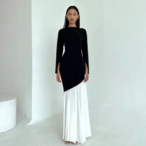 Detail showing the elegant black and white patchwork pleated skirt and long sleeve design