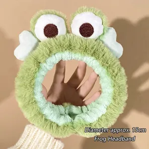 Close-up of plush green frog headband with 15cm diameter size detail and elastic band