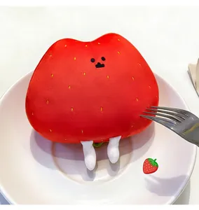 Macro shot of cute strawberry plush doll placed on a white plate with a metal fork