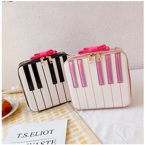 Detailed close-up of piano key patterned handbags with bow accents in black and pink