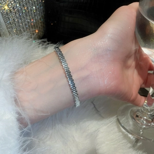 Close-up of silver geometric clasp bracelet with 18k plating and sparkling zircon details