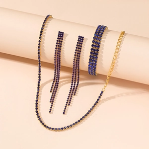 Detailed view of luxury gold jewelry set with deep blue crystals and rhinestones