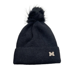 Dettaglio del berretto in maglia nera con logo M in strass e pompon in pelliccia sintetica