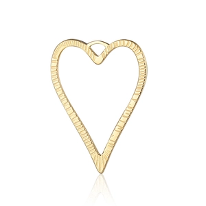 Macro view of a vintage golden heart charm with textured surface for DIY jewelry