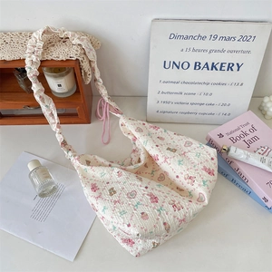 Detail of cute cartoon bear print and frill strap on this cream canvas hobo bag