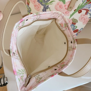 Macro view of floral tote bag interior with metal zipper and reinforced stitching