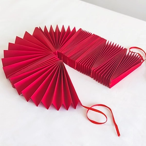 Red accordion pleated paper fans banner for Valentine's Day party and wedding decorations