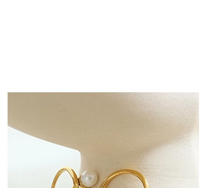 Gros plan d'un collier ras du cou doré avec perle porté sur le cou d'un mannequin